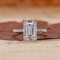 gold emerald cut engagement ring with pave band.
