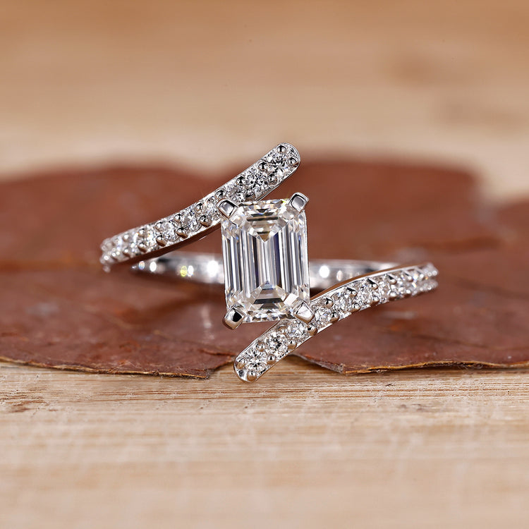 Emerald engagement ring crafted in a bypass setting with a modern twist.
