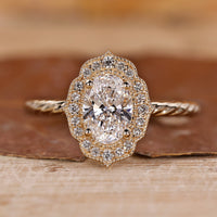 Oval gold engagement ring with halo setting ring.
