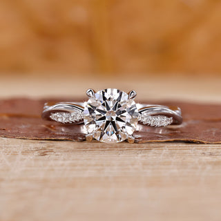 Round diamond engagement ring in a white gold twisted pave ring setting.
