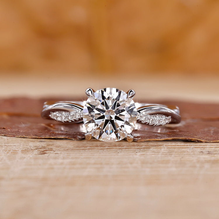 Round diamond engagement ring in a white gold twisted pave ring setting.
