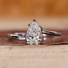 Twisted engagement ring with pear cut diamond in a claw prong setting crafted in white gold.
