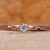 Solitaire diamond ring with round cut diamond and twisted shank in rose gold.
