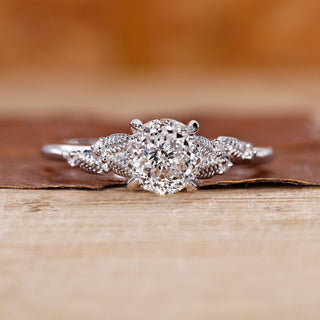 Portuguese cut diamond ring with round side stones in white gold.
