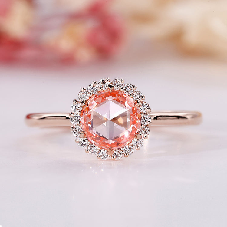 Pink diamond engagement ring with halo design in rose gold.
