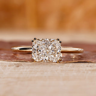 Elongated cushion cut diamond ring with double claw prong in yellow gold.
