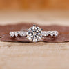 Round cut diamond ring set in a classic white gold band with elegant detail.
