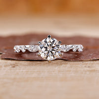 Round cut diamond ring set in a classic white gold band with elegant detail.
