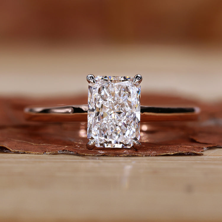 Radiant cut diamond ring in a sleek four prong claw setting.
