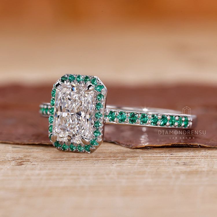 Round emerald pave ring with radiant cut diamond in a white gold claw prong setting.
