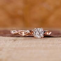 Four heart prong setting ring with round diamond and twisted band.
