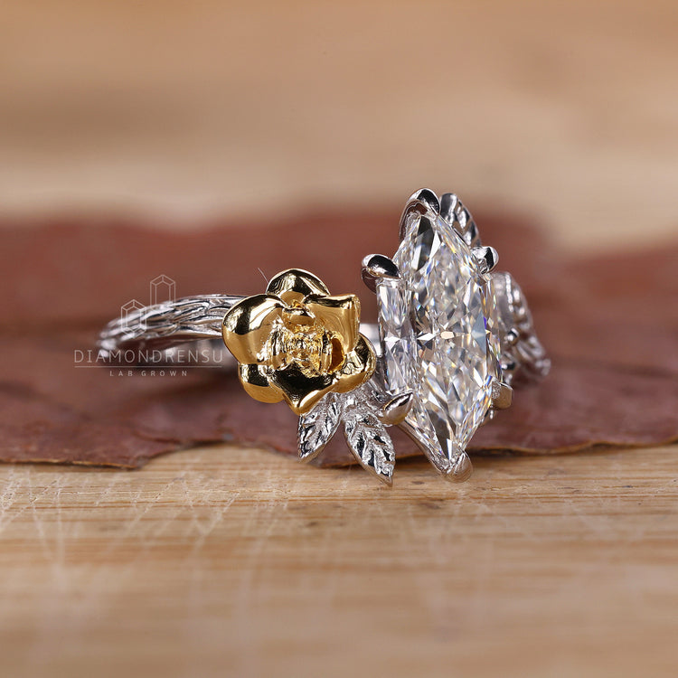 Two tone engagement ring with nature inspired design and Dutch marquise diamond.
