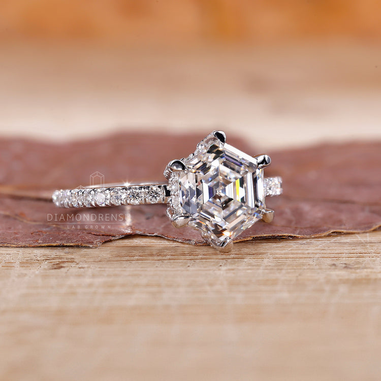 Round diamond halo ring with pavé band and hexagon centre.

