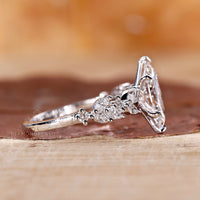 Six claw prong setting ring with marquise cut and round side stones.
