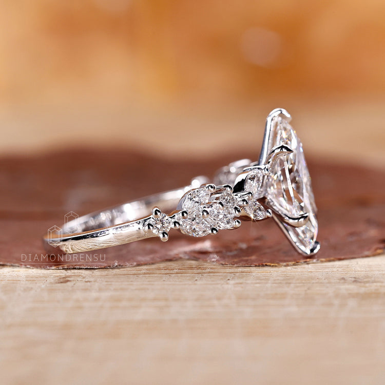 Six claw prong setting ring with marquise cut and round side stones.
