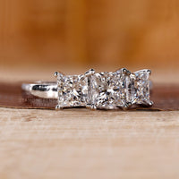 White gold ring with a princess cut centre and side stones.
