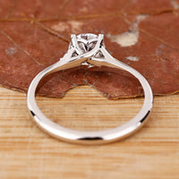 4 prong setting engagement ring with round side stones.
