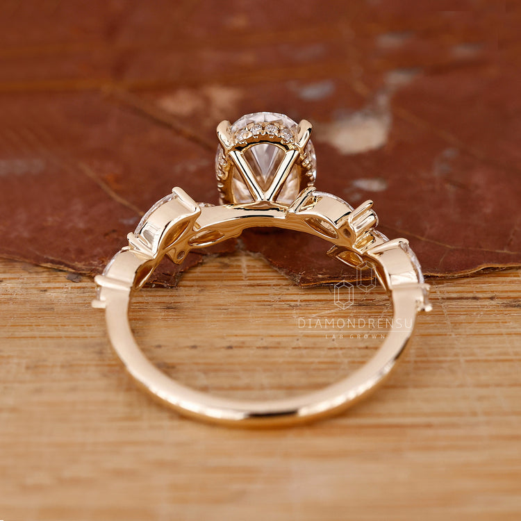 Yellow gold ring with oval diamond and hidden halo design.
