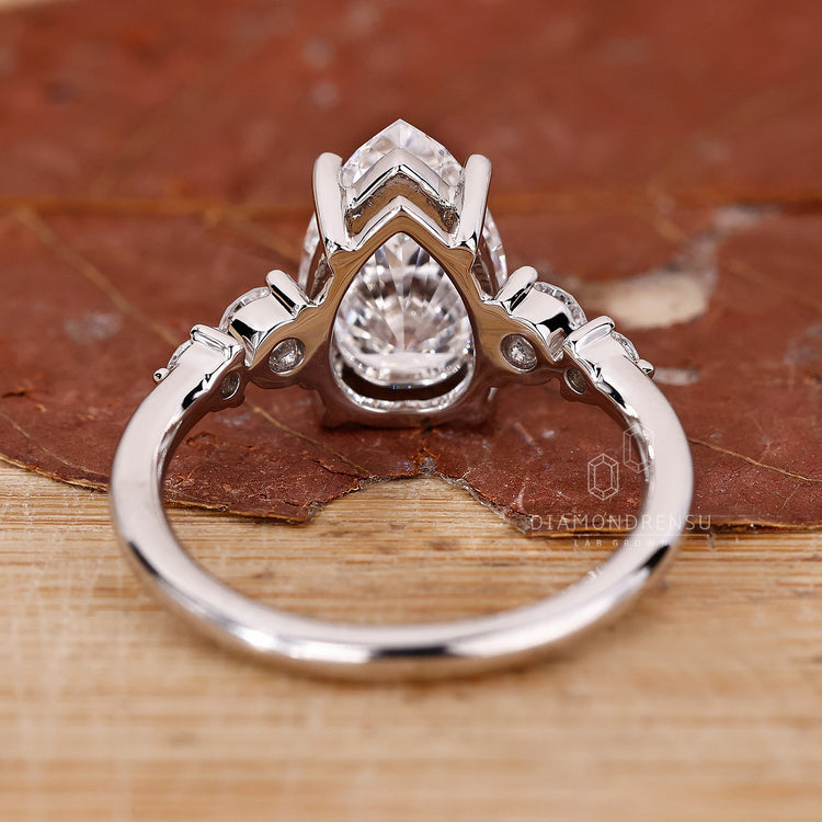 Custom diamond ring designed with pear and round stones in prong setting.
