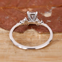 Engagement ring featuring round side stones and cushion cut centre.
