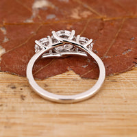 Custom diamond ring with round stones in a trellis setting.
