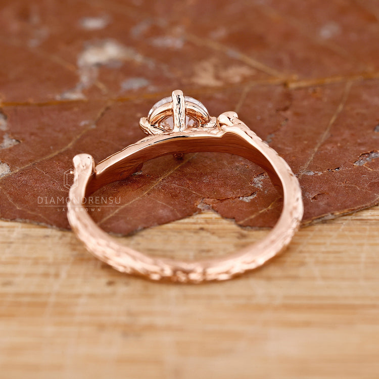 Custom diamond ring in rose gold with round cut and side stones.
