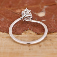 Buy engagement ring with pear cut diamond and twisted band in white gold.
