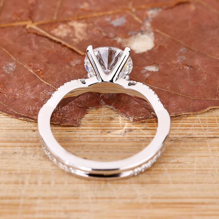 Custom diamond ring with a 4 claw prong and round pave accents.
