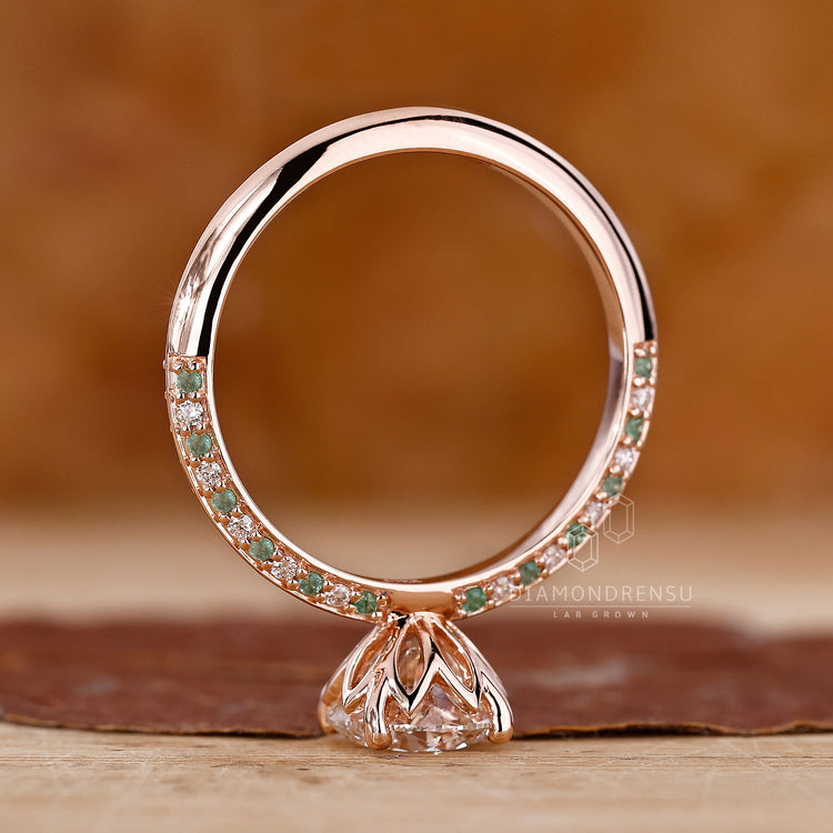Buy engagement ring with round cut diamond and emerald accents.
