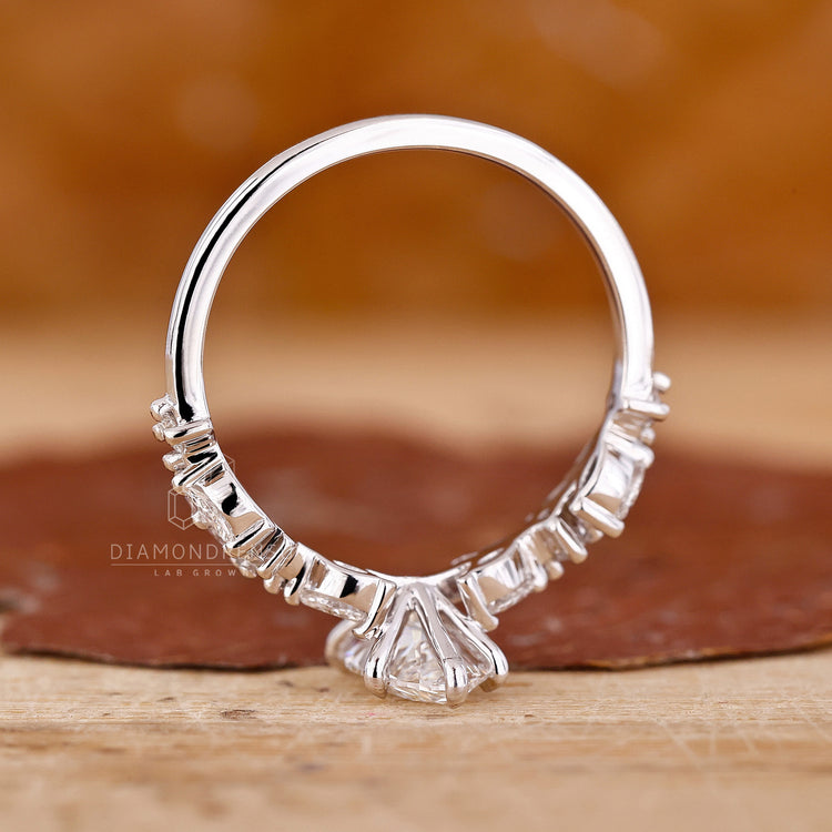 Lab grown diamond marquise ring with round side stones in white gold.
