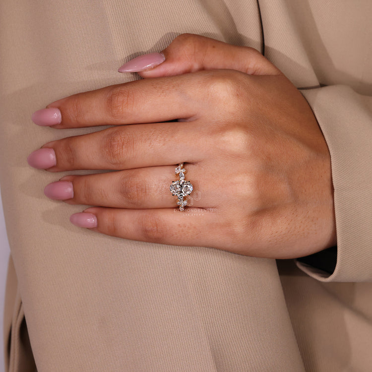 Claw prong ring with oval diamond and marquise side stones in yellow gold.
