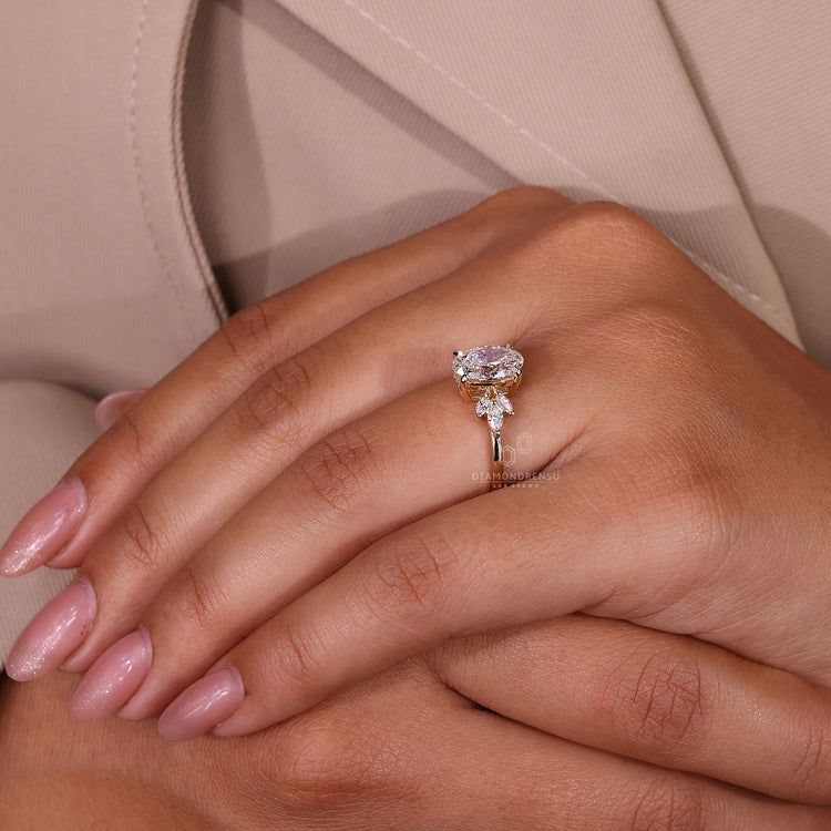 Muse setting ring featuring oval cut diamond and marquise accents in yellow gold.
