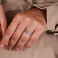 White gold ring with twisted band and claw set pear cut solitaire diamond.
