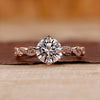 Rose gold diamond ring with round cut diamond and twisted pavé setting.
