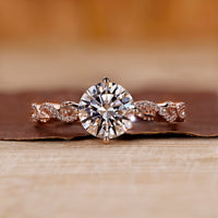 Rose gold diamond ring with round cut diamond and twisted pavé setting.
