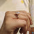 Claw prong setting secures the emerald and pear shaped stones.
