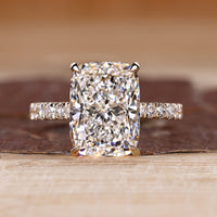 Elongated cushion ring with round diamond pave band.
