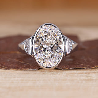 Oval cut diamond ring with half moon side stone.
