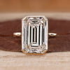 Bezel set emerald cut diamond ring with solitaire design.
