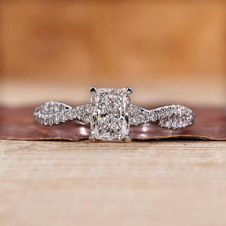 Elongated cushion cut diamond ring with twisted pave band.
