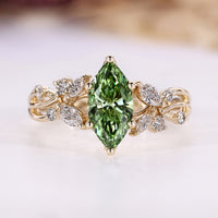 Green diamond ring with round and marquise side stones.