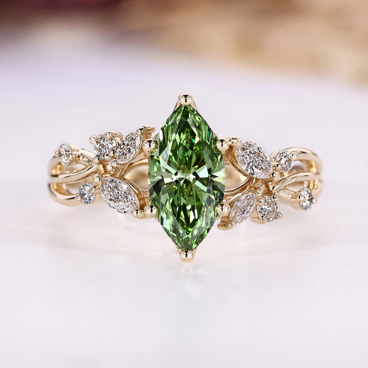Green diamond ring with round and marquise side stones.