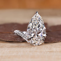 Custom diamond ring with pear centre and pave band.