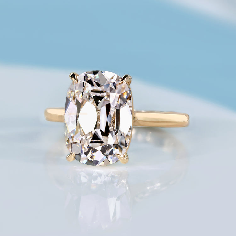 Cushion old mine diamond ring with four claw prongs.