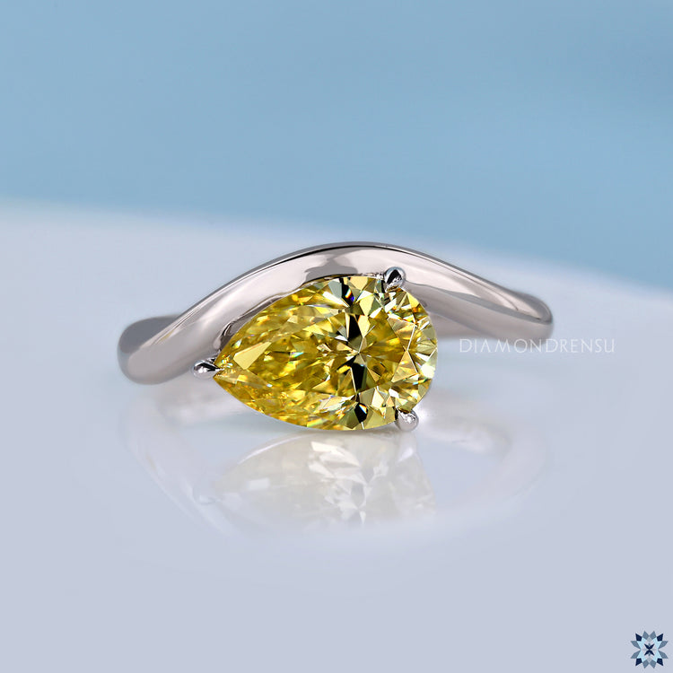 Yellow gold pear diamond ring with curved band design.

