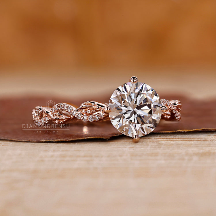 Nature inspired engagement ring with prong set round diamond.
