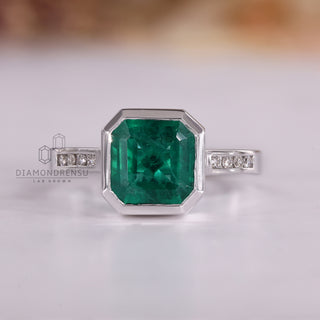 Asscher cut emerald gemstone ring bezel channel set.
