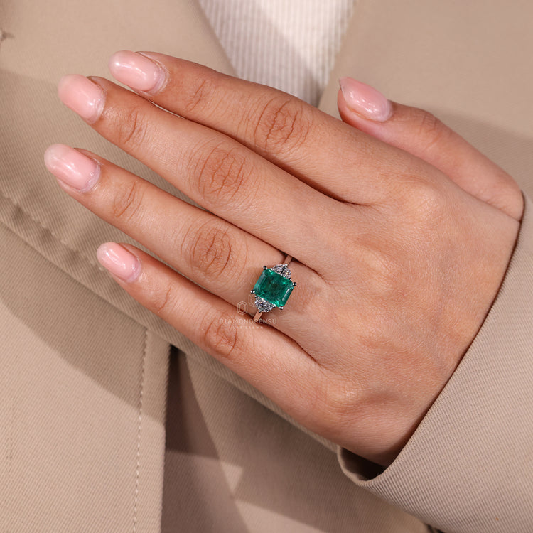 Emerald gemstone ring three stone prong set style.
