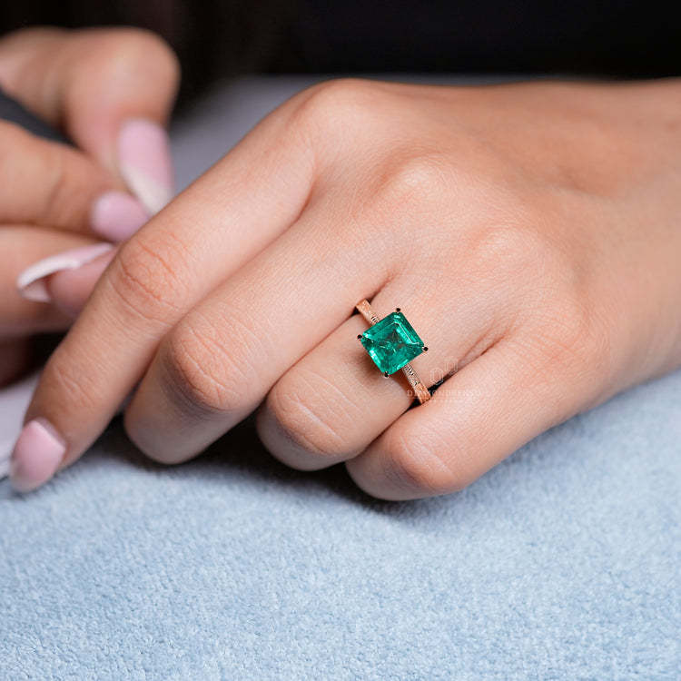 Emerald gemstone ring art deco tapered shank style.
