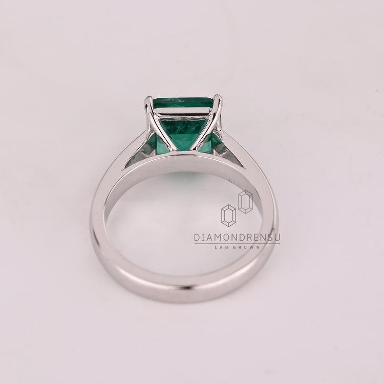 Emerald gemstone ring cathedral setting prong style.
